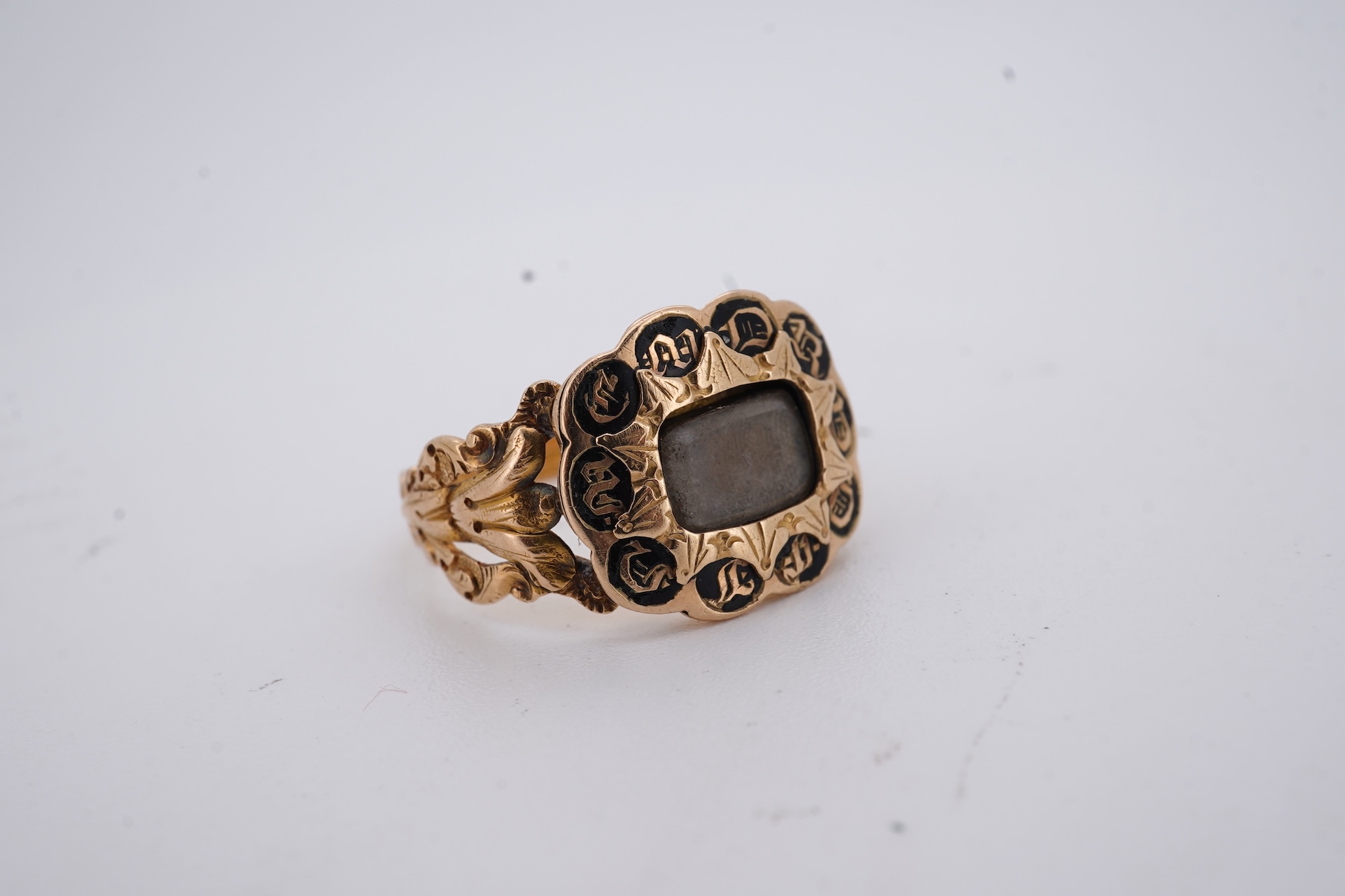 A William IV 18ct gold and black enamel 'In Memory' mourning ring, with hair beneath a central glazed panel, size N, gross weight 2.8 grams.